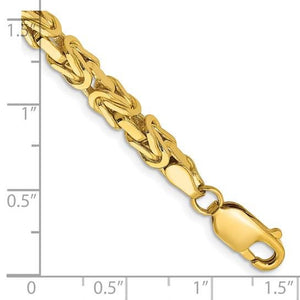Close-up of the 10K gold Byzantine bracelet against an inch ruler