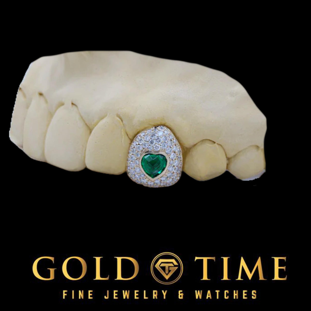 White metal moissanite bustdown cap with a green CZ heart on a dental mold