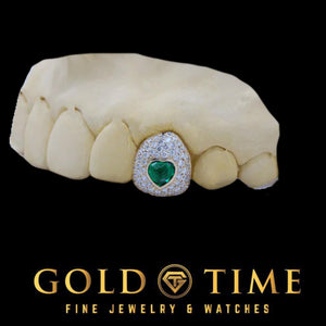 White metal moissanite bustdown cap with a green CZ heart on a dental mold