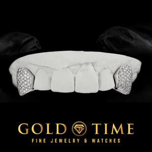 Two iced honeycomb moissanite canine fang caps on a top dental mold with a connecting bar behind the front teeth