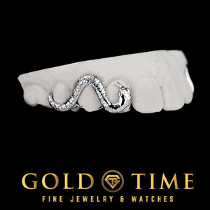 White metal slithering snake grill across three teeth on a dental mold