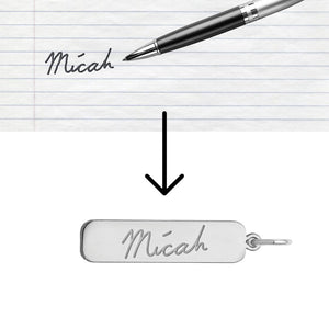 Handwritten name on paper turned into a matching engraving on a silver bar pendant, showing how handwriting is copied
