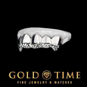 White gold trillion cut tip grillz angled to show the pointed canine fangs