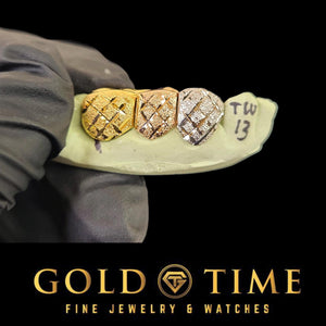 Three tooth tri-color diamond-cut grill on a mold held in a black glove, with handwriting on the mold