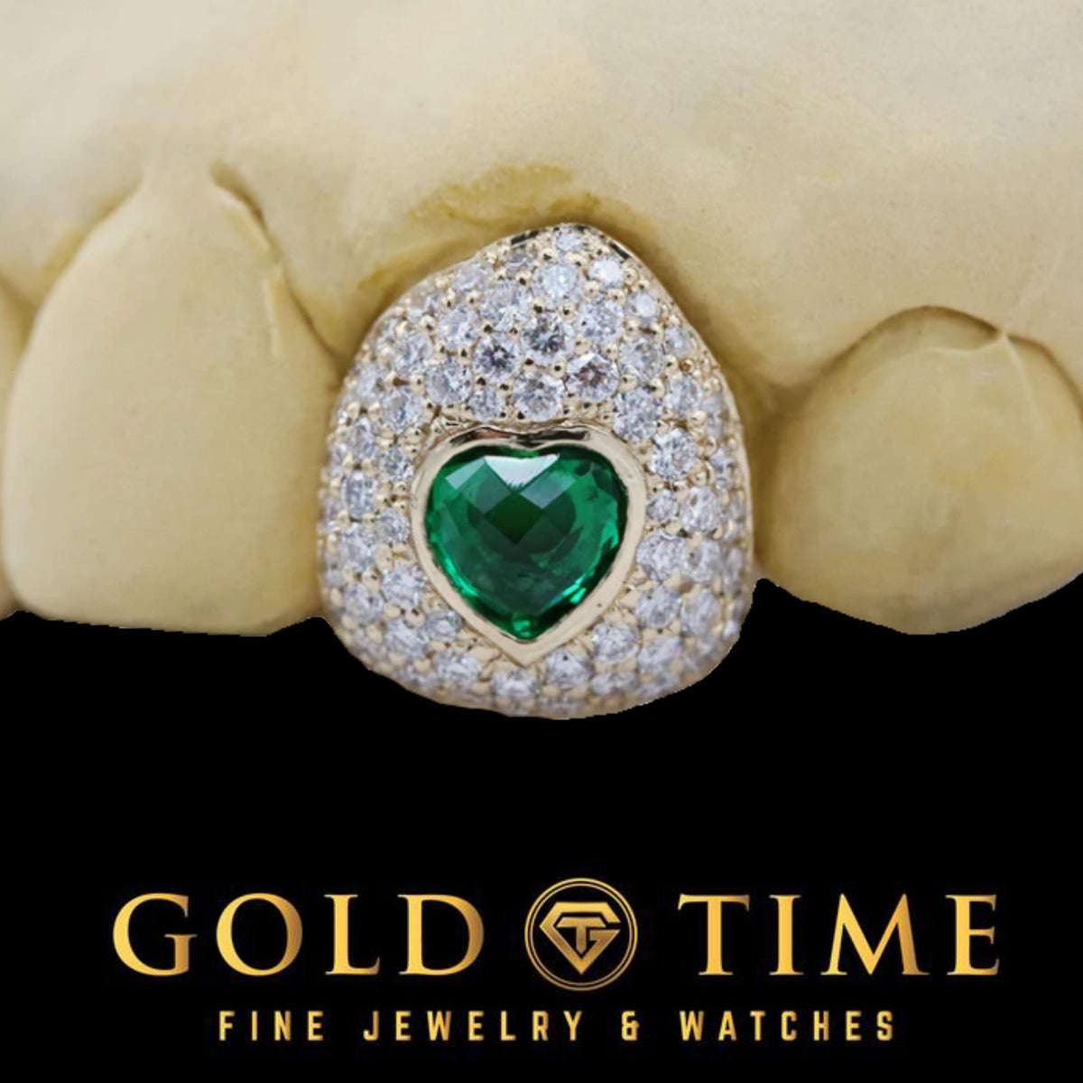 Close-up of a moissanite bustdown cap with a bezel-set green CZ heart in yellow gold