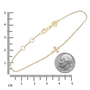 Gold plated diamond cross bracelet laid out beside a dime and a centimeter ruler