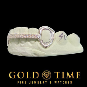 Open face grillz with a pink stone center row set in a light metal frame