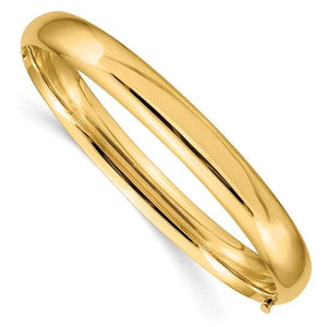 14K gold oval hinged bangle photographed at an angle