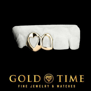 Two yellow gold open face caps with heart shaped cut outs fitted to a dental mold