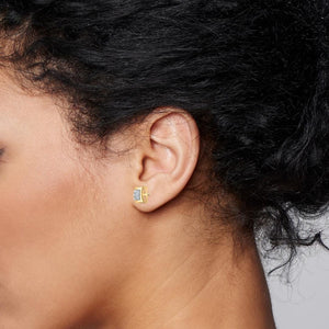Yellow gold square diamond stud worn on a woman's ear