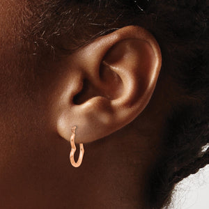 Ear wearing a small rose gold heart hoop earring