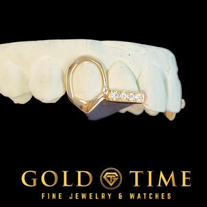 Side view of a gold open face fang cap connected to a moissanite incisor tip bar