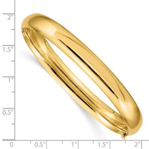 14K gold oval bangle beside a ruler, measuring about 2 inches across