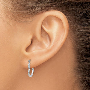 Ear wearing a small white gold heart hoop earring