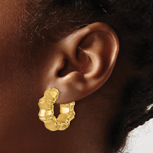 14K gold bamboo hoop earring worn on an ear