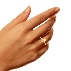 Woman's hand wearing the dainty yellow gold cross diamond ring