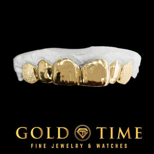Yellow gold 6 piece grillz with solid polished fronts, diamond dust canines and perm cuts on a dental mold