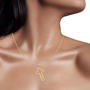 Model wearing a small yellow gold open cross name pendant on a fine chain