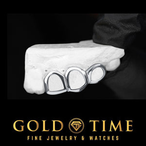 Silver open face triple cap grillz on a dental mold held in a gloved hand, Gold Time
