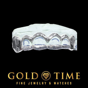 White gold 6 piece grill with solid canines and open window front teeth with diamond dust tips on a mold