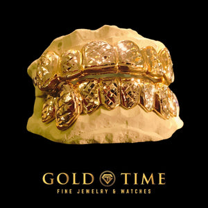 Trillion cut box design carried across a full top and bottom gold grillz set on molds