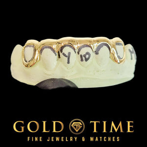 Close-up of 6 piece bottom open face grillz with spike tips on a dental mold