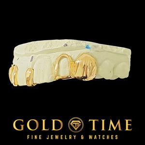 Yellow gold solid canine and open face incisor grillz on a mold, angled view