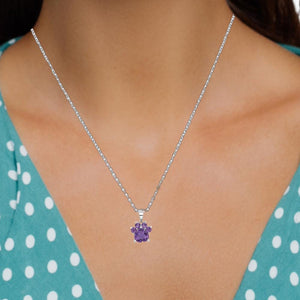 Woman wearing a sterling silver paw pendant with an amethyst center stone