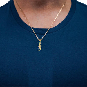 Man in a navy shirt wearing the yellow gold treble clef name pendant on a fine chain