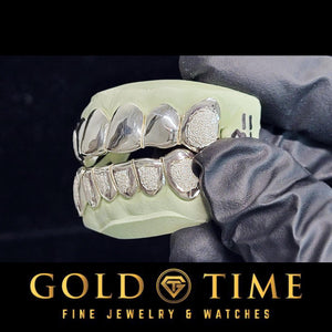 White gold 12 piece diamond dust grillz set held in a gloved hand