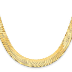 14K gold herringbone chain laid in a curve on a white background