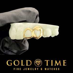 Gold heart cut out open face caps on a dental mold held in a gloved hand, Gold Time