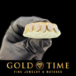 Gloved hand holding a two-tone diamond dust box grill on a bottom mold