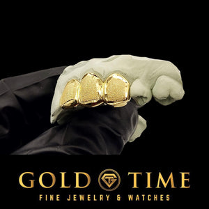Gold teeth grillz held by a gloved hand with 'Gold Time' branding.