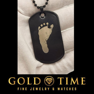 Black stainless steel dog tag engraved with a baby footprint, an example of specialty image engraving