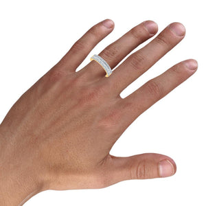 Man's hand wearing the 14k gold men's diamond wedding band with a center row of baguette diamonds