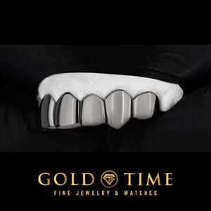 Angled view of black rhodium perm cut grillz on a mold