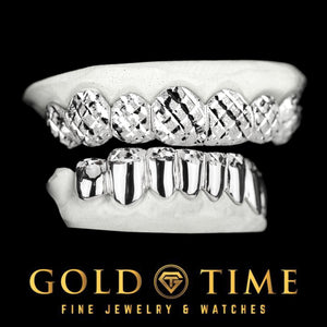 Angled view of a 16 piece trillion diamond-cut top and solid dust tip bottom grillz set