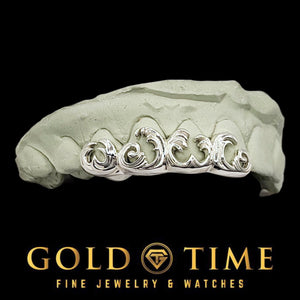 Angled view of 4 piece white 3D wave grillz on a mold
