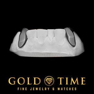 Two solid black canine grillz caps on a mold, front view
