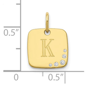 Yellow gold cushion initial charm against a half inch scale, about 11mm square