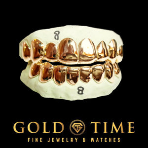 Front view of a custom 16 piece solid gold grillz set, 8 top and 8 bottom, on molds