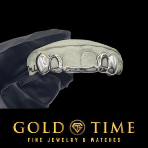 Custom 6 piece silver tip bar grillz with open face laterals and solid canines on a dental mold held in a gloved hand, Gold Time