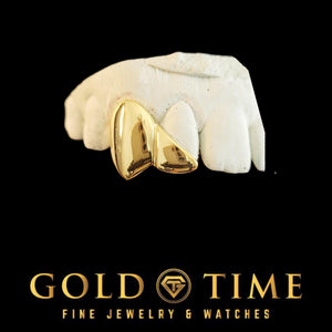 Custom yellow gold 2 piece grillz with a solid canine fang and diagonal cut incisor cap on a dental mold