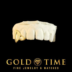 Yellow gold canine fang cap grill on a top dental mold, side view