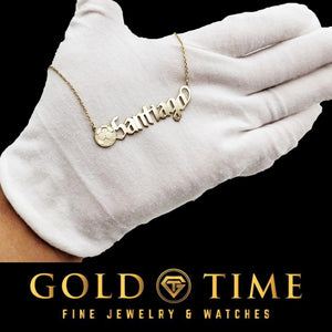 Gold soccer ball name necklace held in a white-gloved hand to show scale