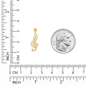 Yellow gold treble clef pendant shown next to a quarter for scale on a centimeter ruler