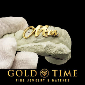 Gold 'Mrs.' grill on a stone with Gold Time Fine Jewelry & Watches logo.