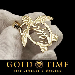 Gold sea turtle name pendant held in a gloved hand to show its size