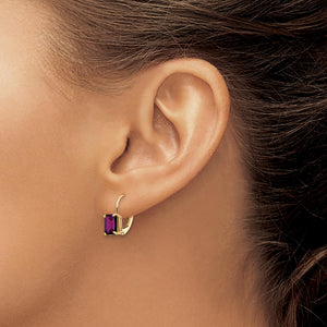 Close-up of an ear wearing a 14k gold leverback earring with a purple emerald-cut stone